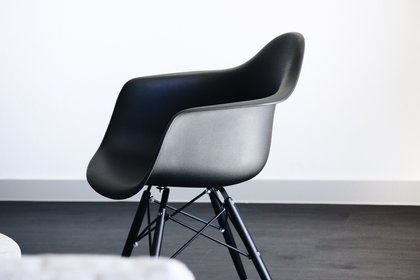 Design für alle Moderner, dunkelgrauer Stuhl vor weißer Wand